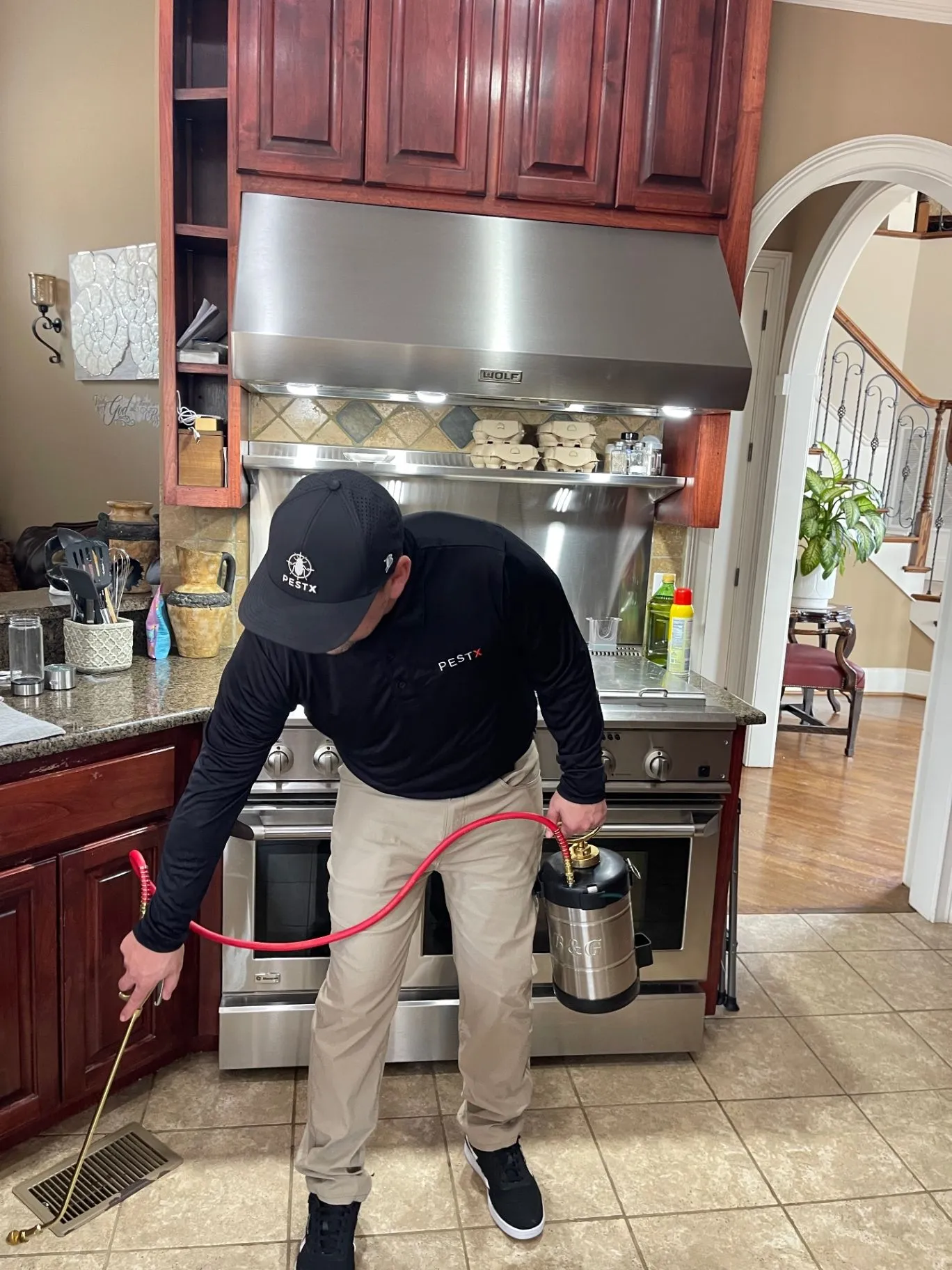 Pest X owner applying an interior general pest treatment in a home.